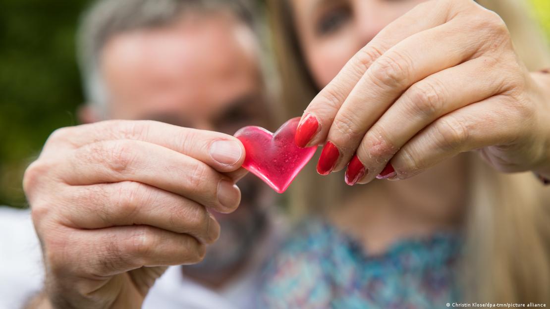 Dos personas sostienen un corazón. 