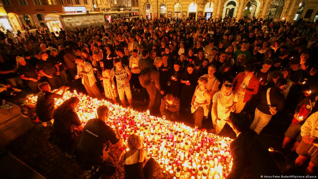 Una gran cantidad de personas frente a un homenaje con velas y flores en Graz, luego del ataque a una escuela en el que murieron 11 personas.