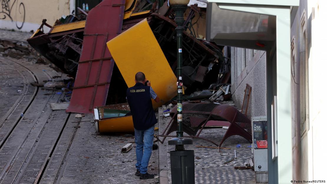 Un agente de Policía toma una fotografía en el lugar del accidente del funicular Elevador da Glória, en Lisboa.