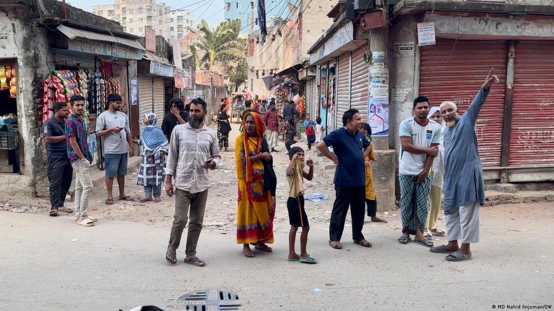 Vecinos de Daca reunidos en una calle comentan sobre el terremoto y observan hacia los edificios. (21.11.2025)