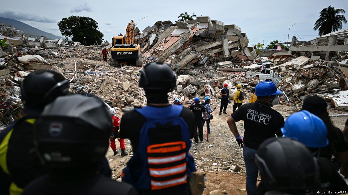 Voluntarios y paramédicos permanecen inmóviles mientras los rescatistas realizan pruebas de sonido en busca de sobrevivientes tras los dos terremotos en Caraballeda, estado de La Guaira. (30.06.2026)