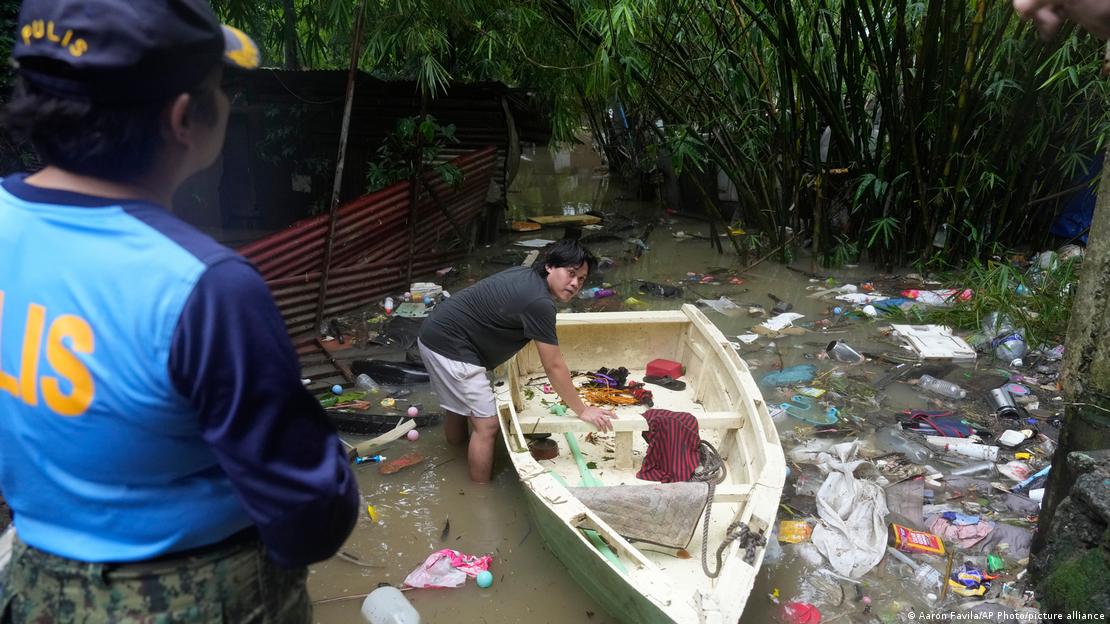 Un hombre prepara su embarcación en medio de aguas de inundación contaminadas, provocadas por las intensas lluvias monzónicas estacionales, en la localidad de Bagong Silangan, Quezon City, Filipinas. (10.08.2026).