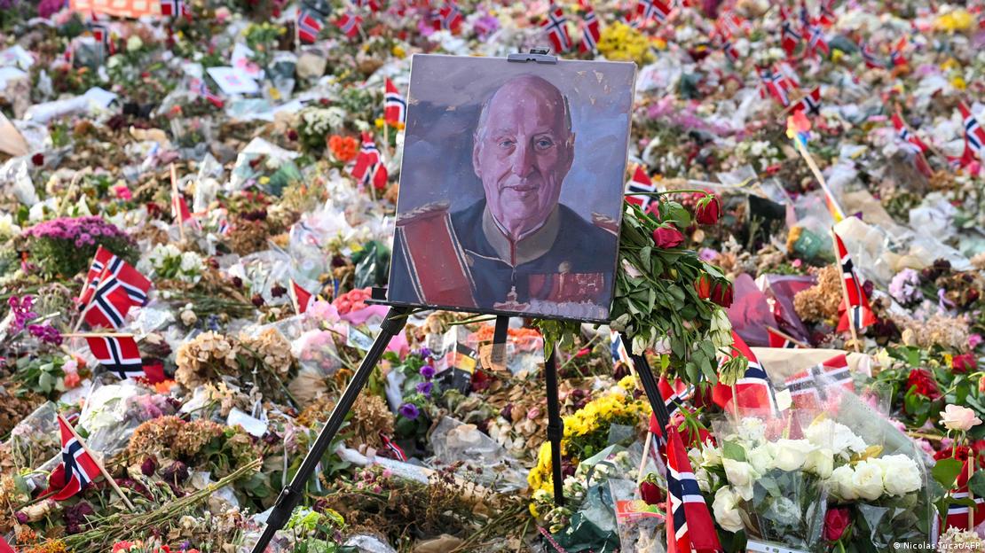 Retrato del difunto rey Harald V de Noruega, expuesto entre flores y banderas noruegas frente al Palacio Real de Oslo, en vísperas de su funeral de Estado.