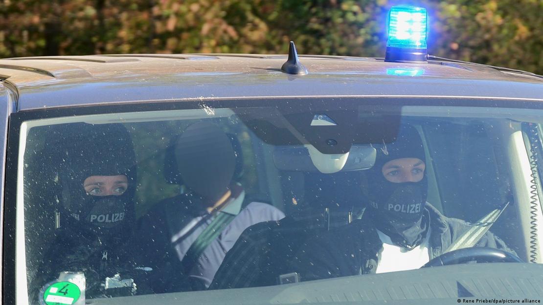Vehículos policiales con dos agentes enmascarados en la parte frontal trasladan a Manfred D., ex director administrativo de los servicios de inteligencia (BND) de Alemania hacia el Tribunal Supremo Federal. (6.10.2026).