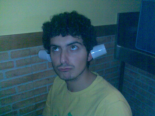 Haciendo el tonto con dos vasos en las orejas