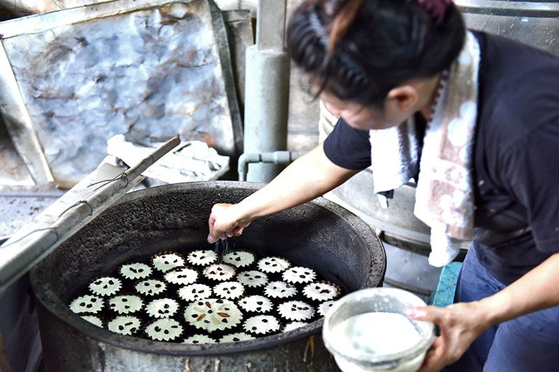 ขนมฝรั่งกุฎีจีน สีเหลืองนวลโรยหน้าด้วยลูกเกด ฟักเชื่อม พลับอบแห้งและน้ำตาลทราย อบร้อนๆ ในเตาแบบโบราณ