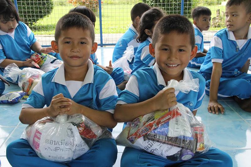 เด็กๆ ยิ้มอย่างมีความสุขที่ได้รับของ
