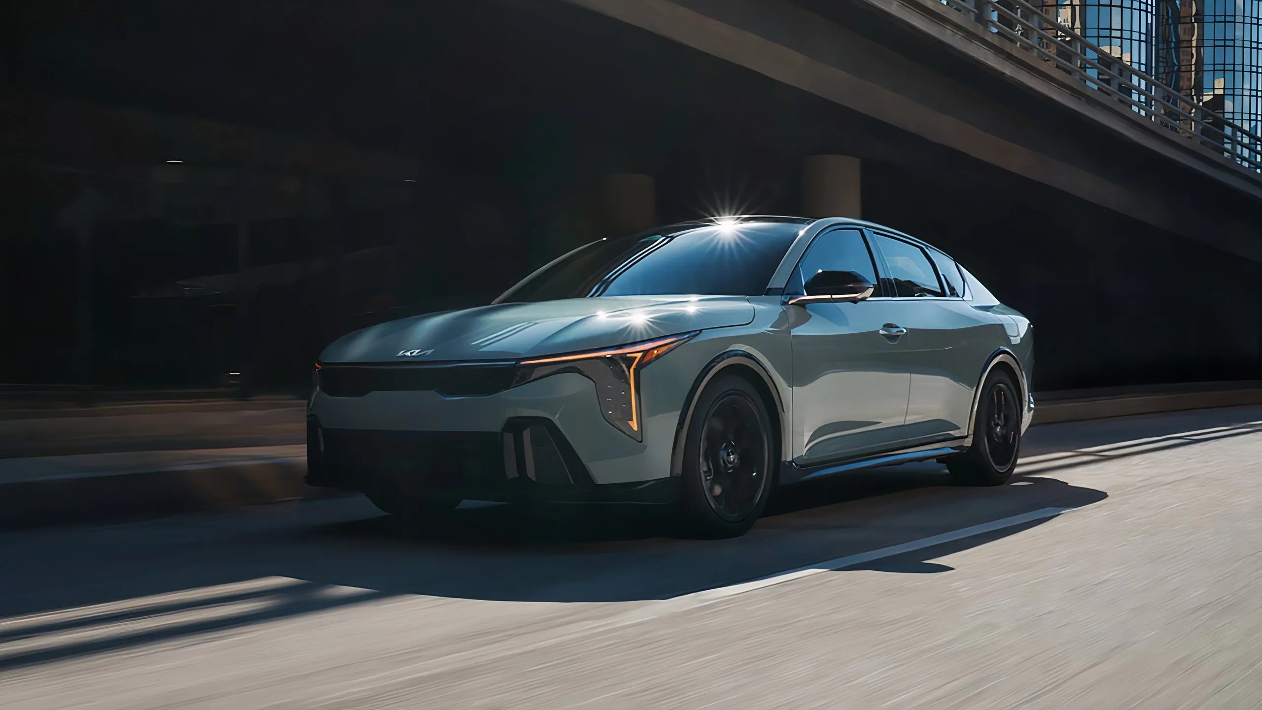 Une photo immobile de la Kia K4 2025 qui roule dans la rue. 