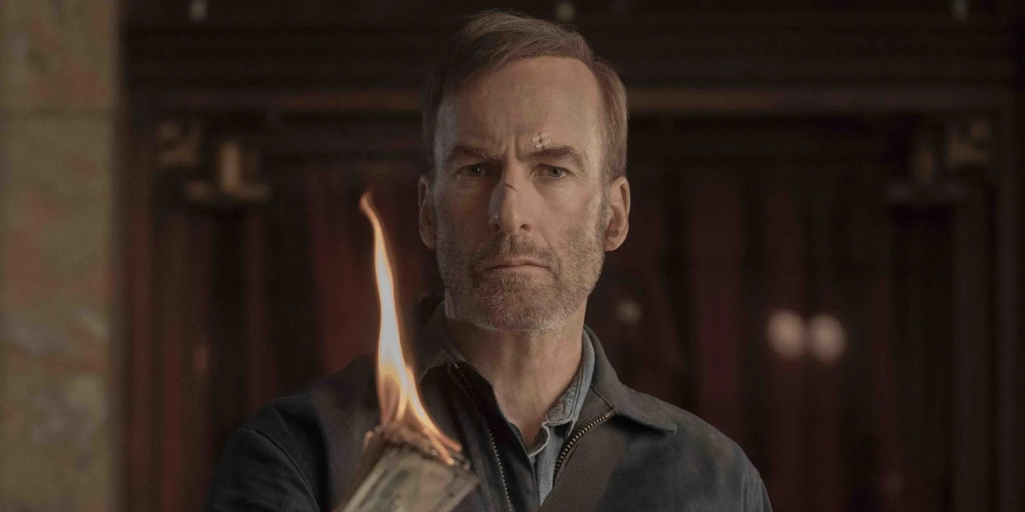 Hutch mira sin comprender mientras sostiene una pila de dinero ardiendo en Nadie.