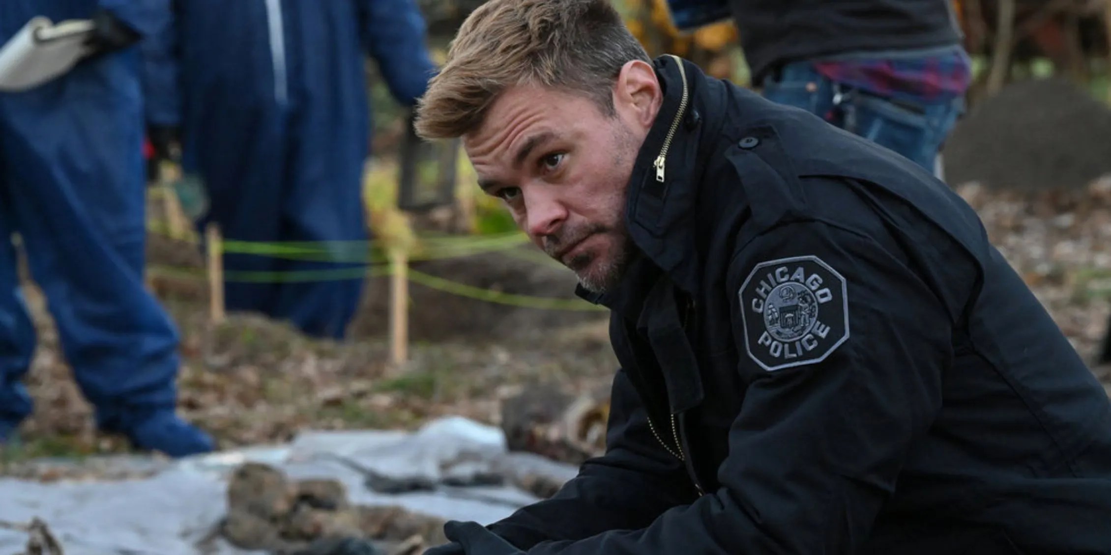 El policía de Chicago Ruzek en uniforme arrodillado junto a los restos de personas asesinadas