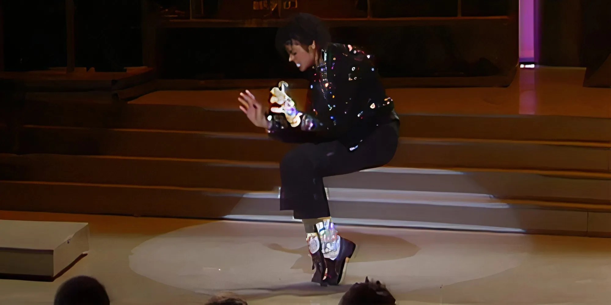 Michael Jackson actúa 'Billie Jean' en Motown 25 y golpea un soporte para los pies con su chaqueta negra, guante blanco y calcetines brillantes.