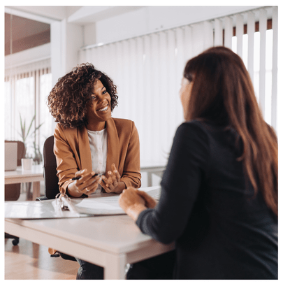 Image of a statistical consulting session with two women seated over a table. The image is designed to show one woman as a statistician and the other as a client. We provide this service in SC for stat analysis, data science, data analytics, and business intelligence.