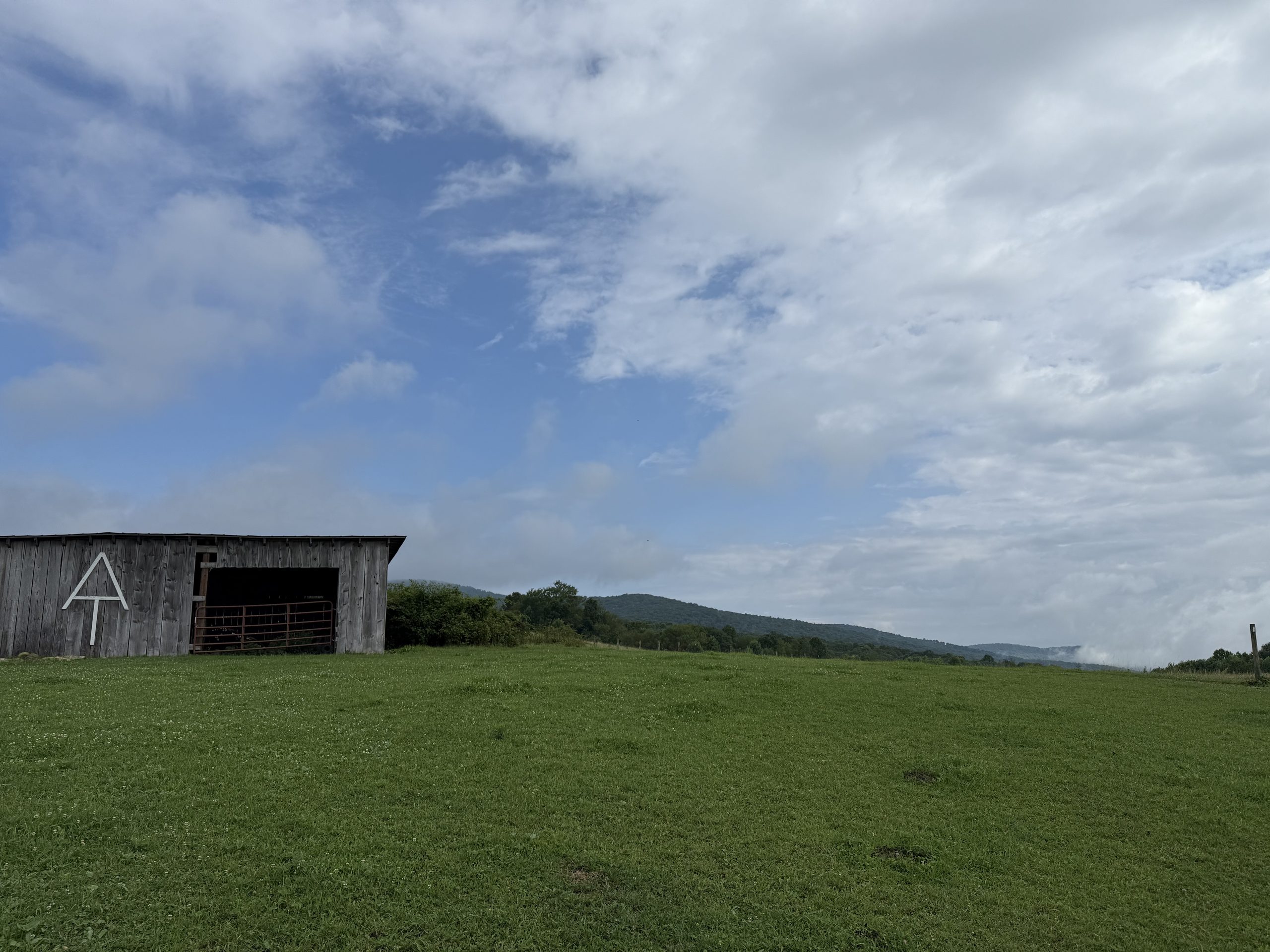 View of the barn with the AT logo and mountains in the distance.
