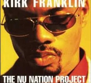 Close up of Kirk Franklin, pensive. He's wearing sunglasses and he's looking down