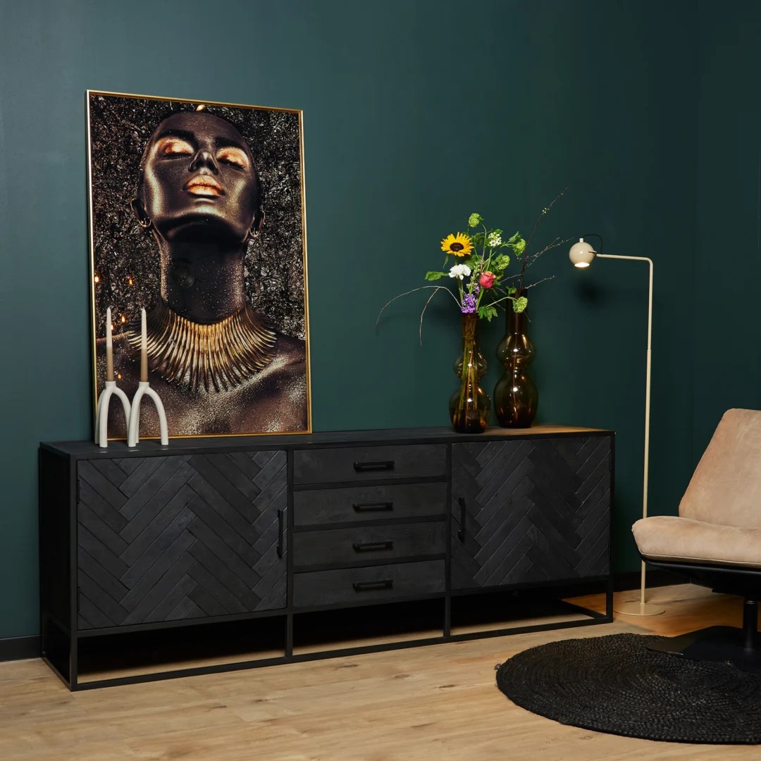 De REALITY Tafellamp EARL heeft een modern ontwerp met een ronde, geribbelde groene glazen kap en een goudmetalen voet, die een warme, uitnodigende gloed uitstraalt wanneer hij brandt.