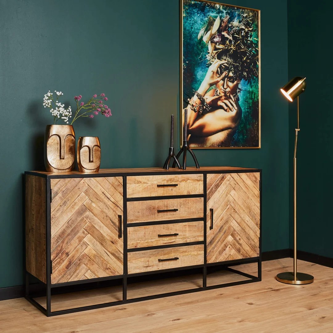 Een moderne woonkamer met de Dressoir Arlington 165 cm, gouden vazen met bloemen, een ingelijst abstract portret op een donkergroene muur en een gouden vloerlamp op een lichthouten vloer.