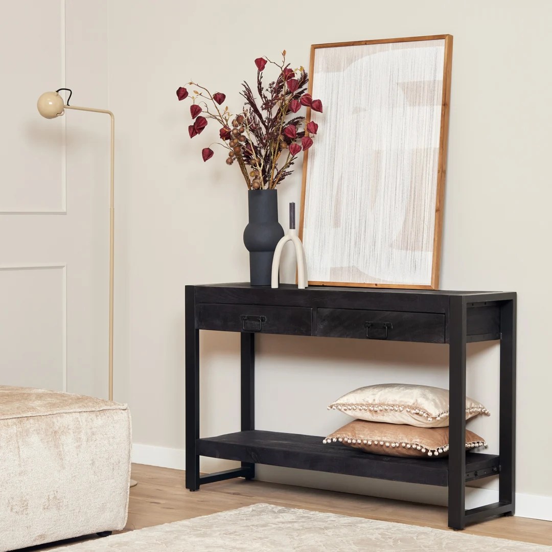 De TRIO Tafellamp Gila heeft een modern ontwerp met een ronde, open kap van zwart metaaldraad die de lamp onthult, op een ronde voet met een aangesloten netsnoer en schakelaar.