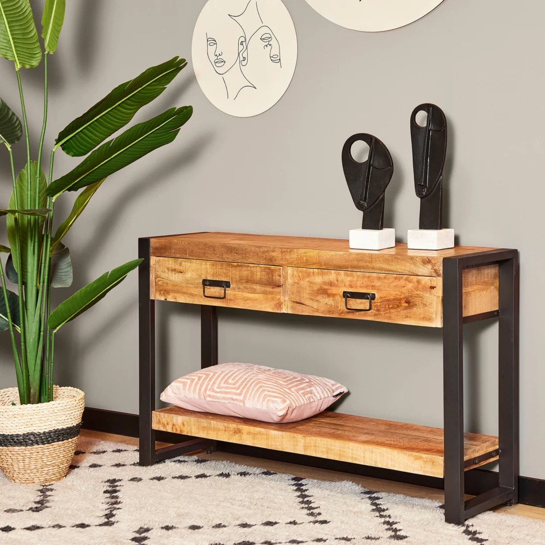 De TRIO Tafellamp Bale heeft een modern ontwerp met een cilindrische oranje voet en bijpassende ronde lampenkap. De lamp straalt een zachte gloed uit en heeft een zwart netsnoer tegen een effen witte achtergrond.