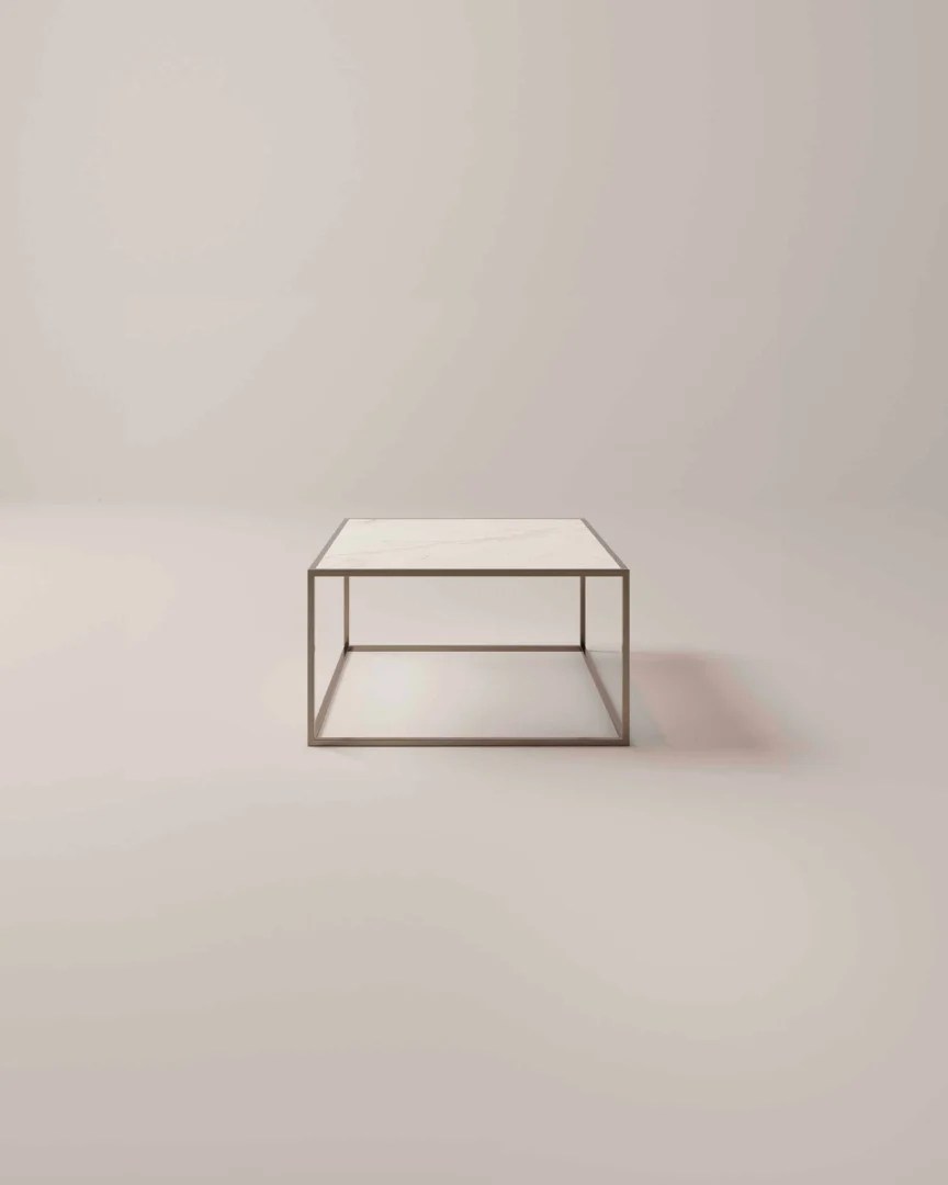De REALITY Tafellamp LOLA is een decoratieve tafellamp met een gouden flamingovormige voet die op één poot staat, met zijn kop en nek gebogen boven een zwarte lampenkap.
