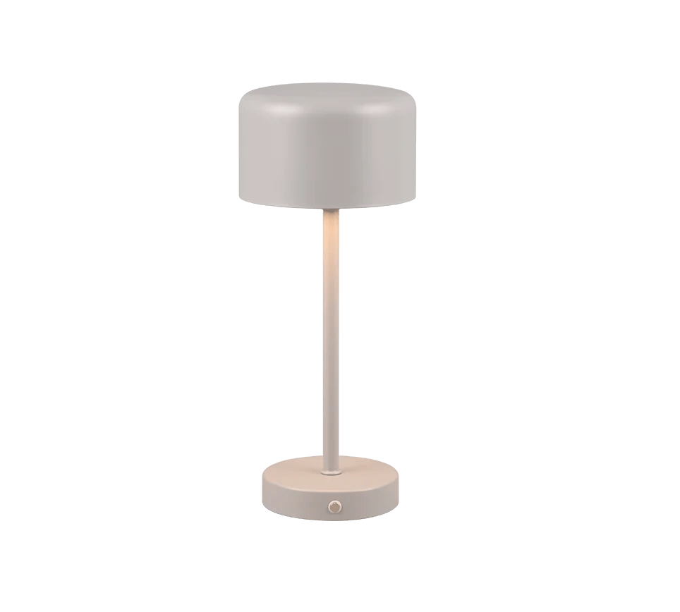 De REALITY Tafellamp JEFF heeft een modern, minimalistisch ontwerp met een cilindrische voet, slanke verticale steel en koepelvormige kap in een zachte, neutrale kleur. Ingeschakeld werpt hij subtiel neerwaarts licht.