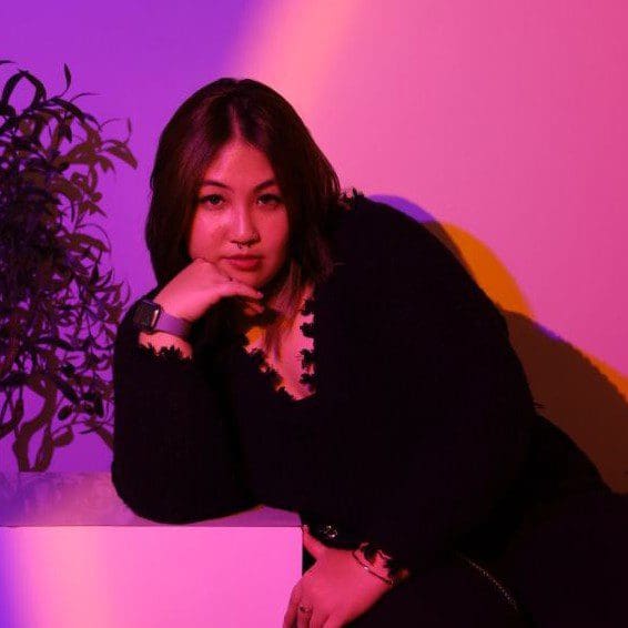 ภาพ portrait ของ Zellyn Lo บนพื้นหลังไล่ระดับสีชมพูและสีม่วง