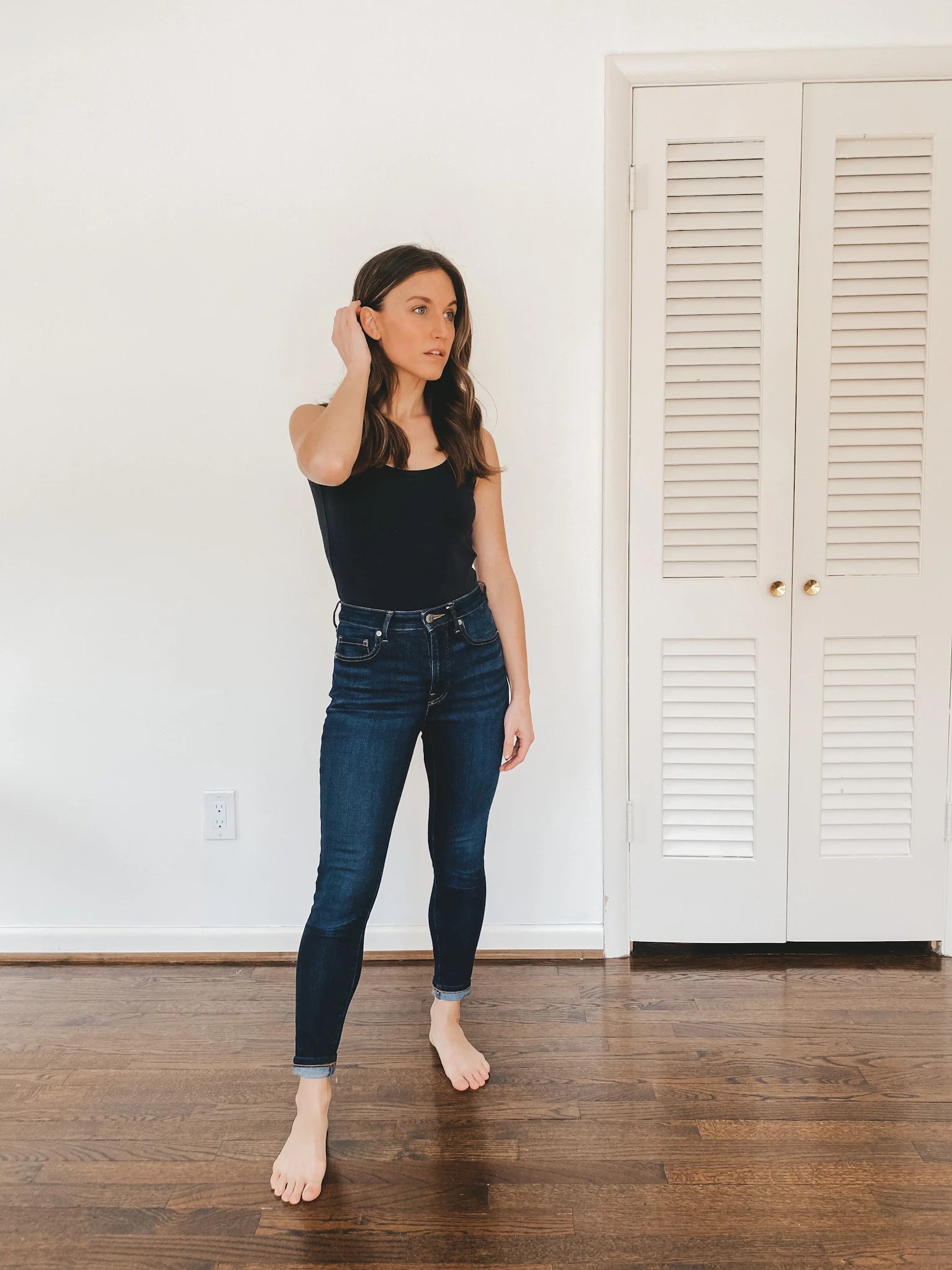 ashley wearing an Everlane black sleeveless bodysuit and deep indigo Authentic Stretch High Rise Skinny Jeans from Everlane