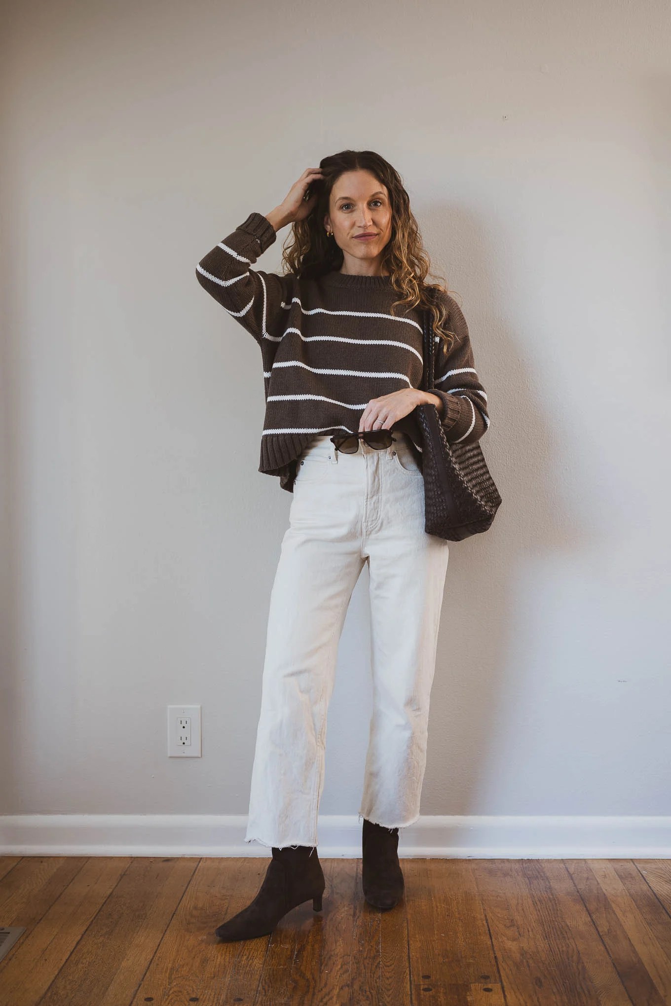 fall capsule outfit with a striped sweater, ecru jeans, and brown boots