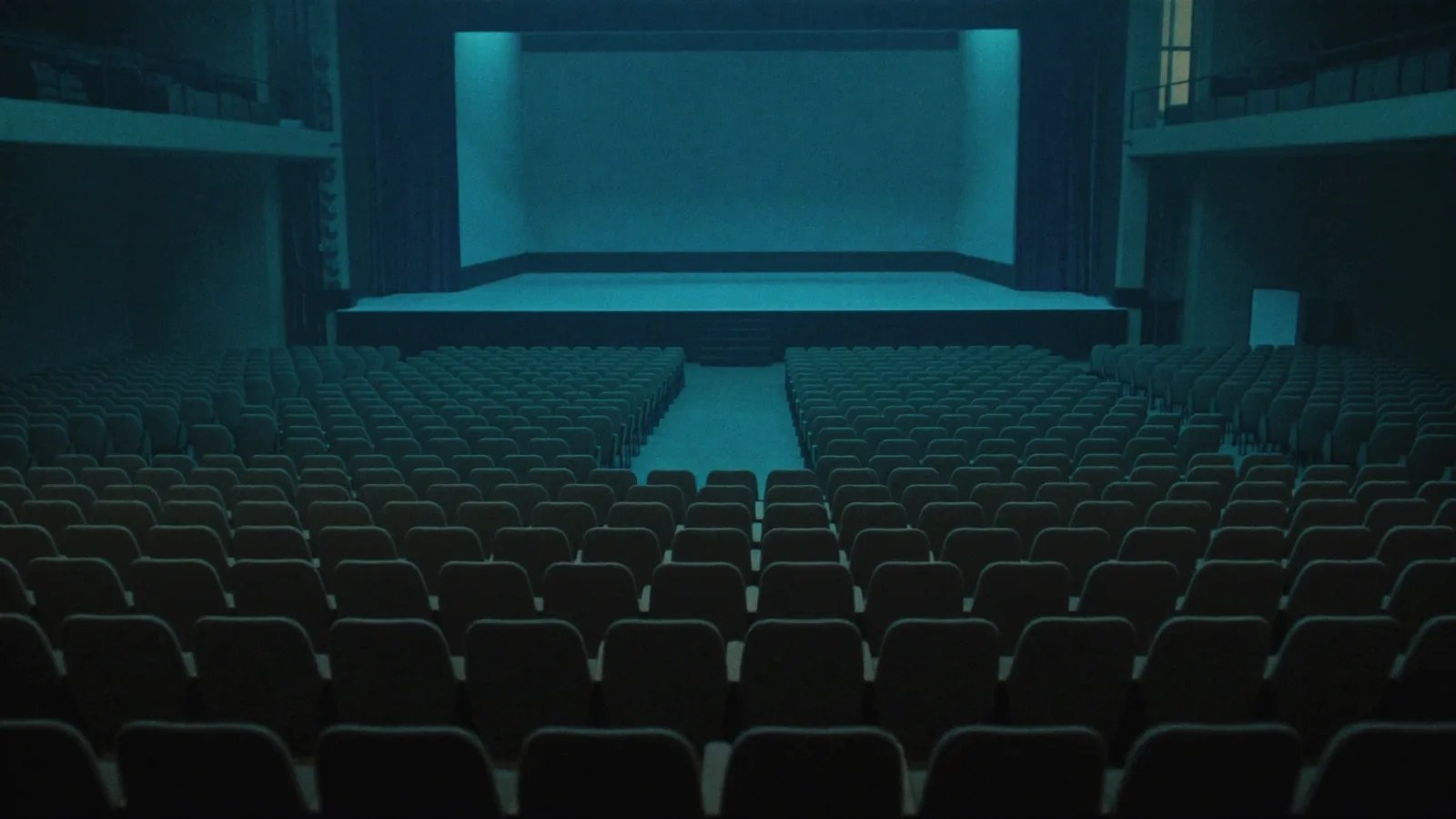 An empty, ominous modern assembly hall with a cold glow