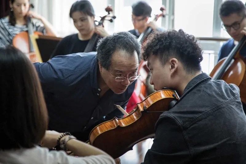 cellist yo-yo ma examining a student's viola playing