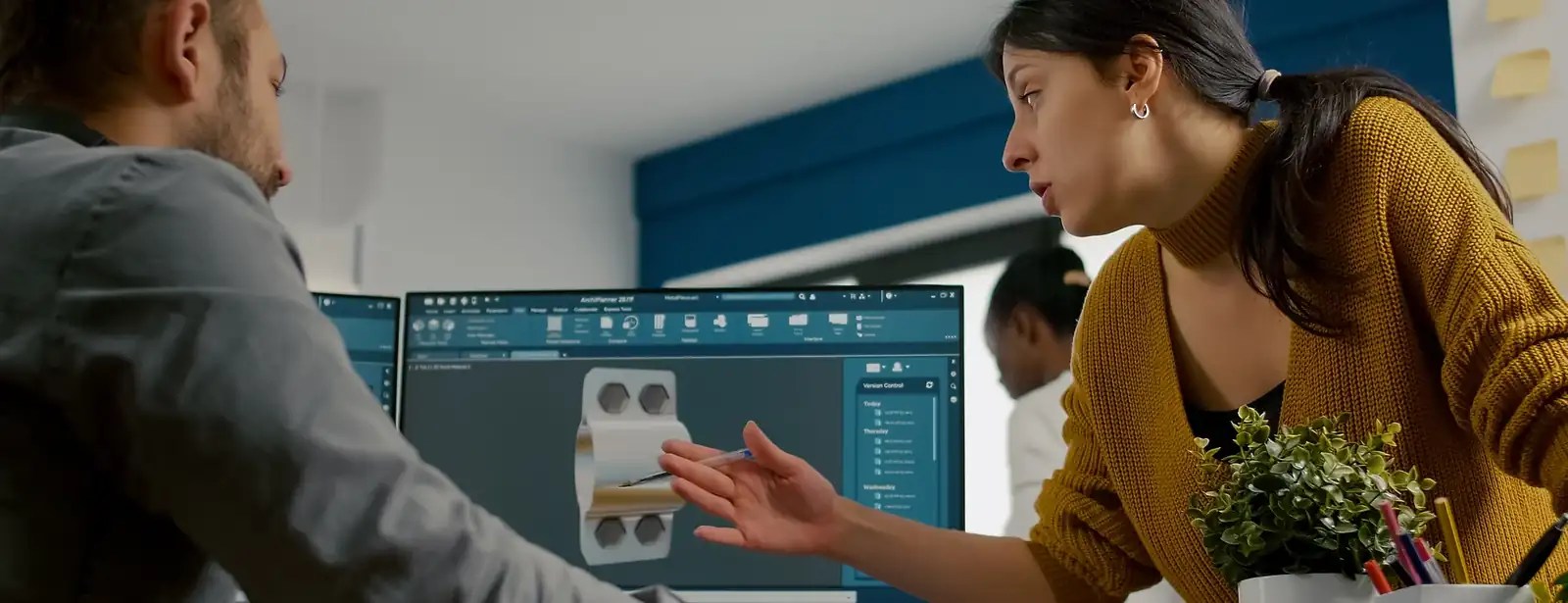 Design professionals discussing a digital model at a workstation