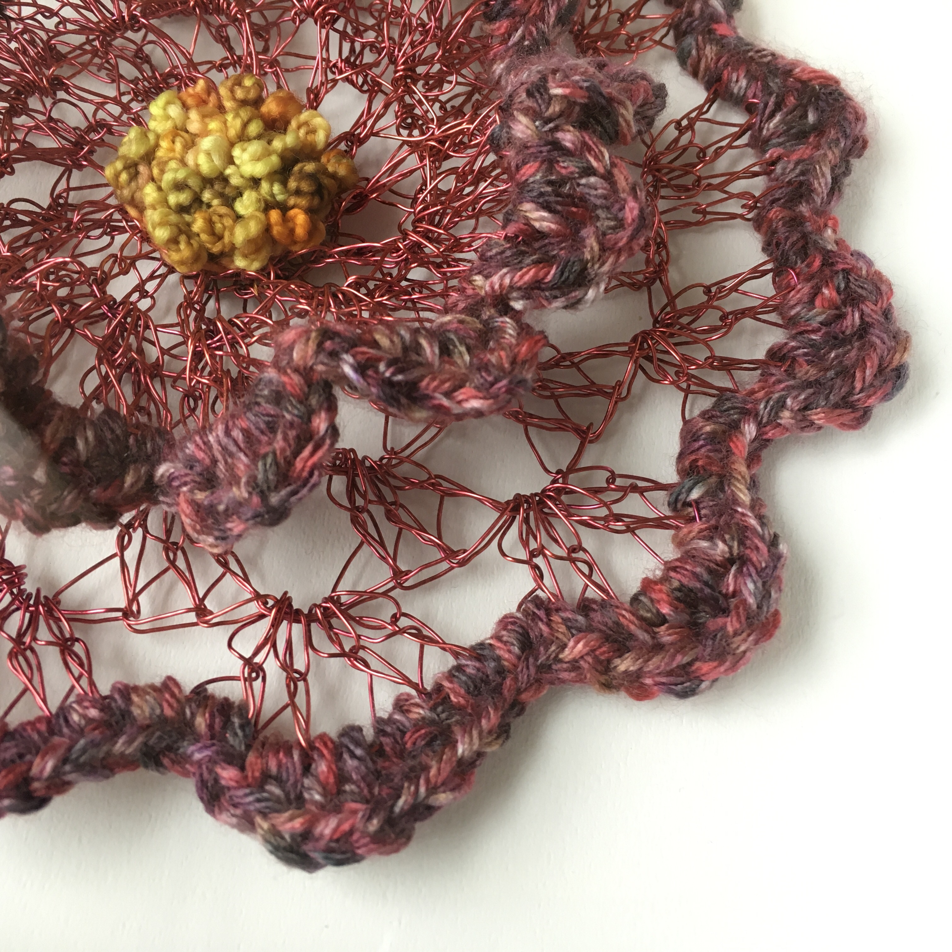 Detail photograph of wire and fiber hand crafted flower wall art