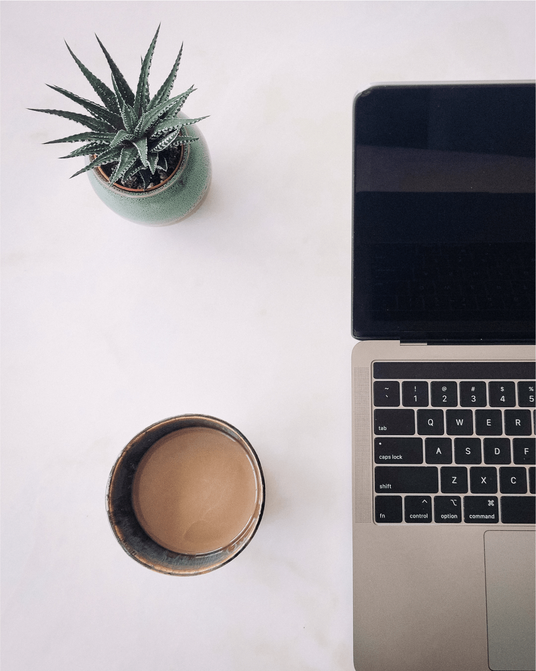 Minimal workspace with coffee cup and laptop on soft neutral background