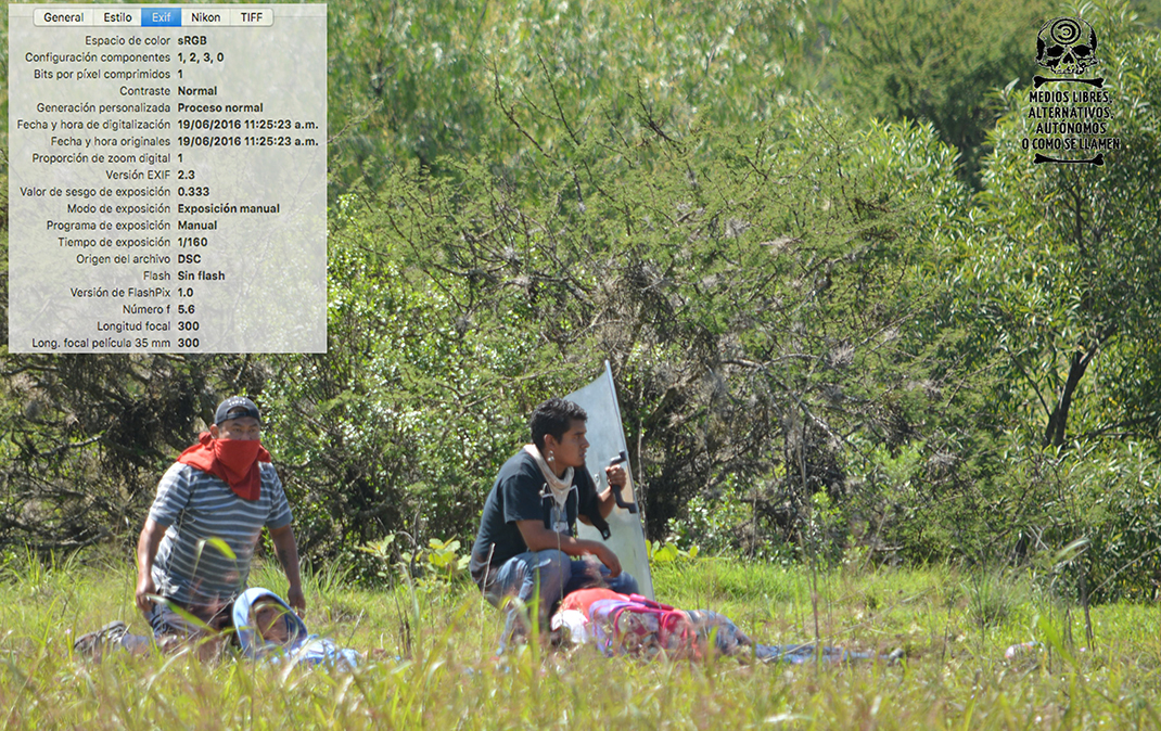 [Foto 9] 11:25:23 am. Yalid Jiménez, yace en el suelo sin poder levantarse, las dos personas que tratan de auxiliarlos están hincadas ya que en ese momento continuaba la policía disparando hacia ese lugar.