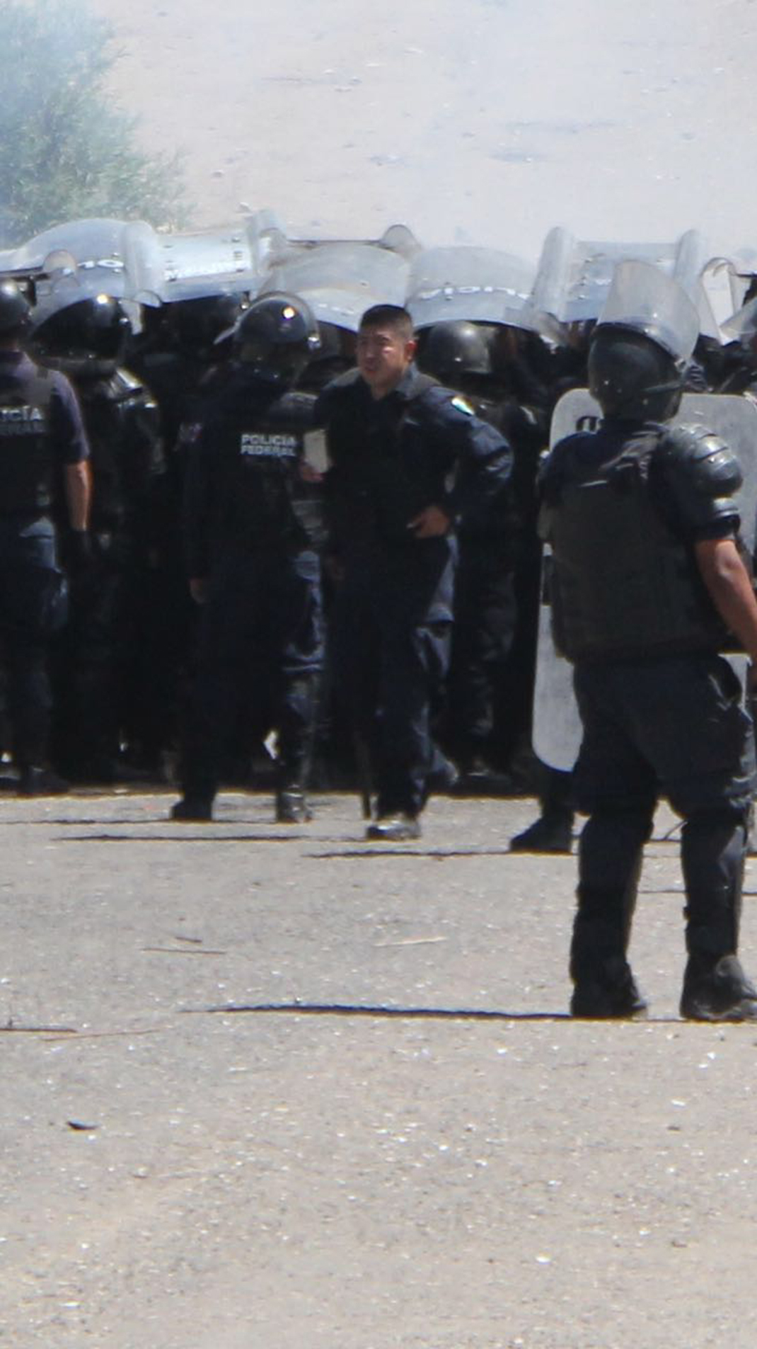 [Foto cortesía] 11:21:23 a.m. Se ve a un elemento policial documentando con su móvil, en la parte trasera junto a la camioneta de policía vial, se aprecia un elemento con un arma larga. Foto Cortesía: Mismo elemento, nos lleva a deducir que la propia corporación policial tiene las evidencias de quienes dispararon ese día