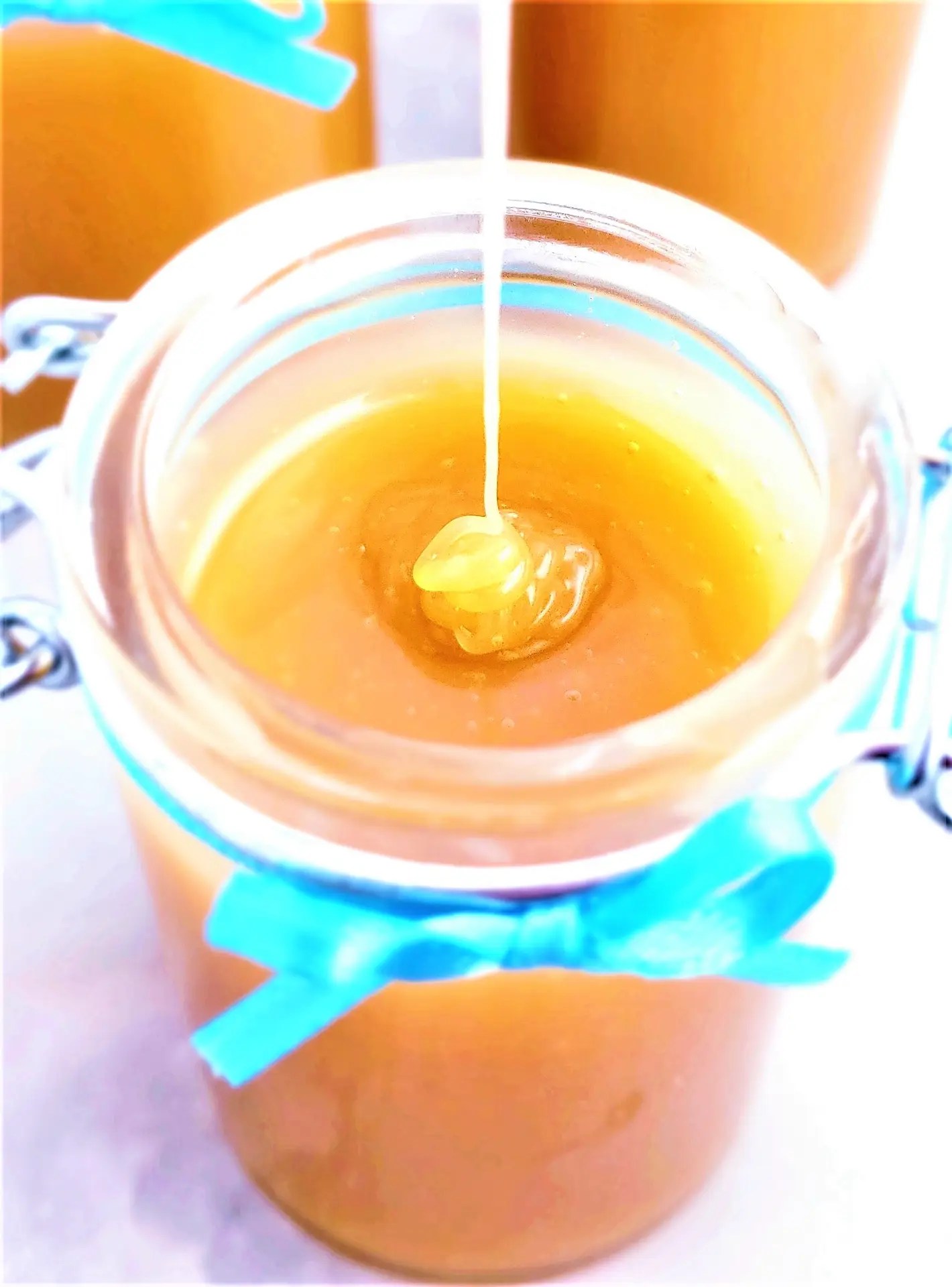 A glass jar filled with golden, smooth Homemade Caramel Sauce