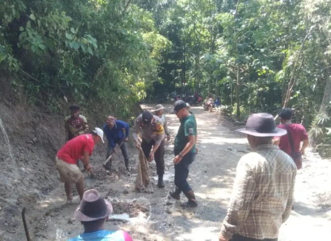 Anggota Polsek Cibugel, Polres Sumedang, Polda Jabar bersama warga berjibaku membersihkan meterial tanah longsor di Betulan Jalan Gunung Gebos yang menghubungkan Desa Cipasang Kecamatan Cibugel, dengan Kecamatan Wado Kabupaten Sumedang. Jumat (05/05/2023).
