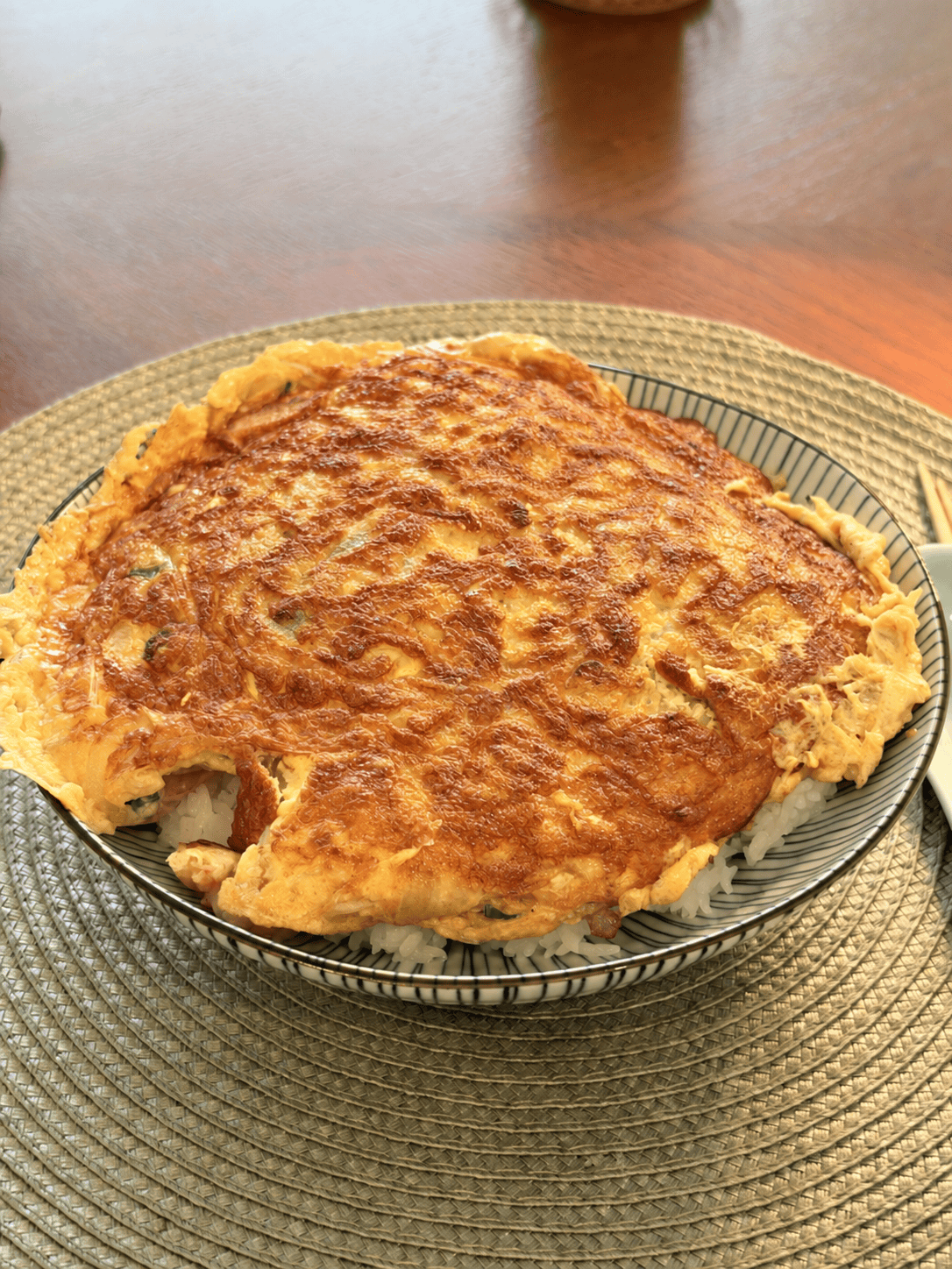 Egg Foo Young Rice served on a patterned plate, with a golden omelette over steamed rice