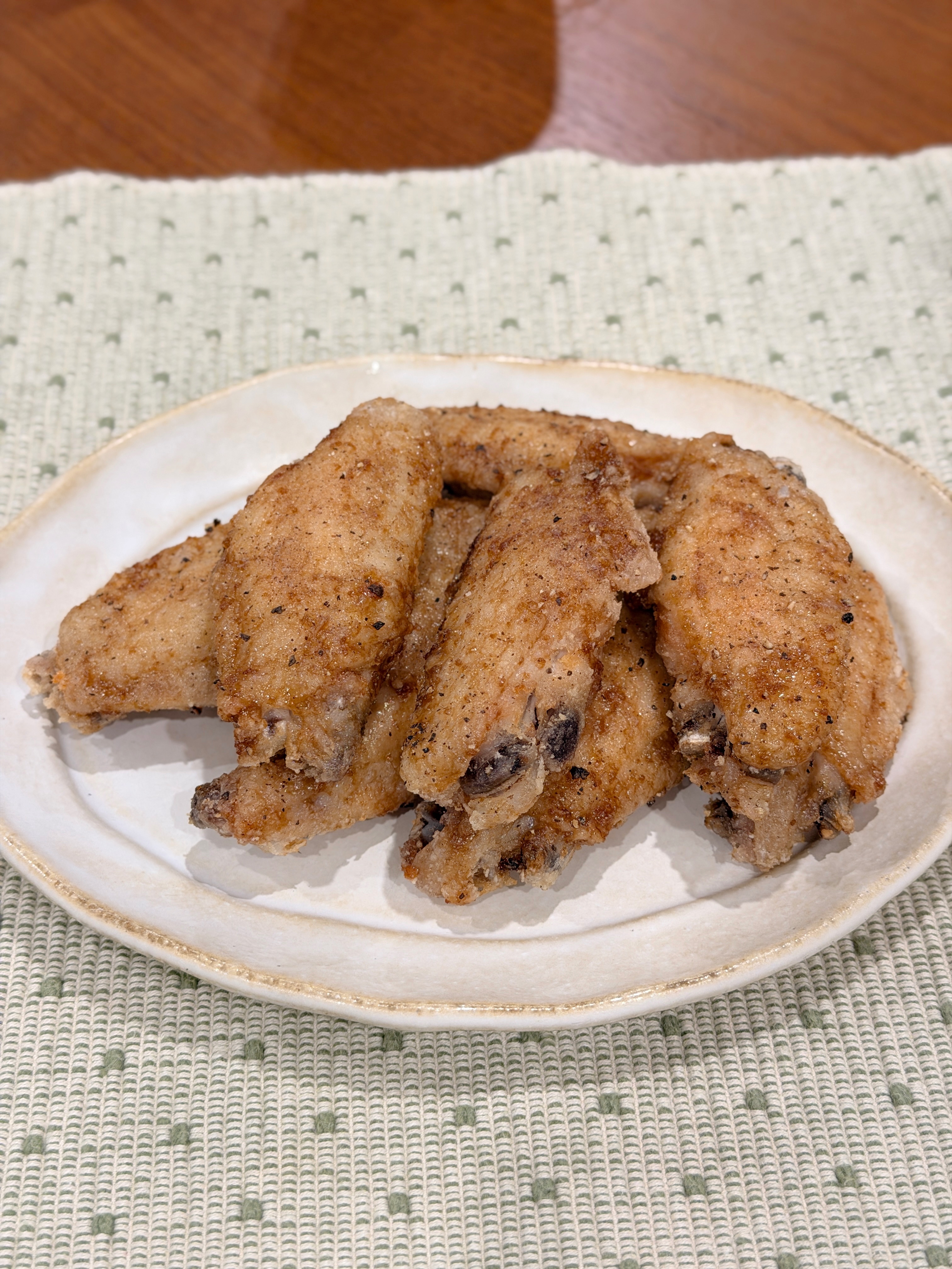 Yamachan-inspired crispy chicken mid-wings served on a cream plate over a green patterned cloth