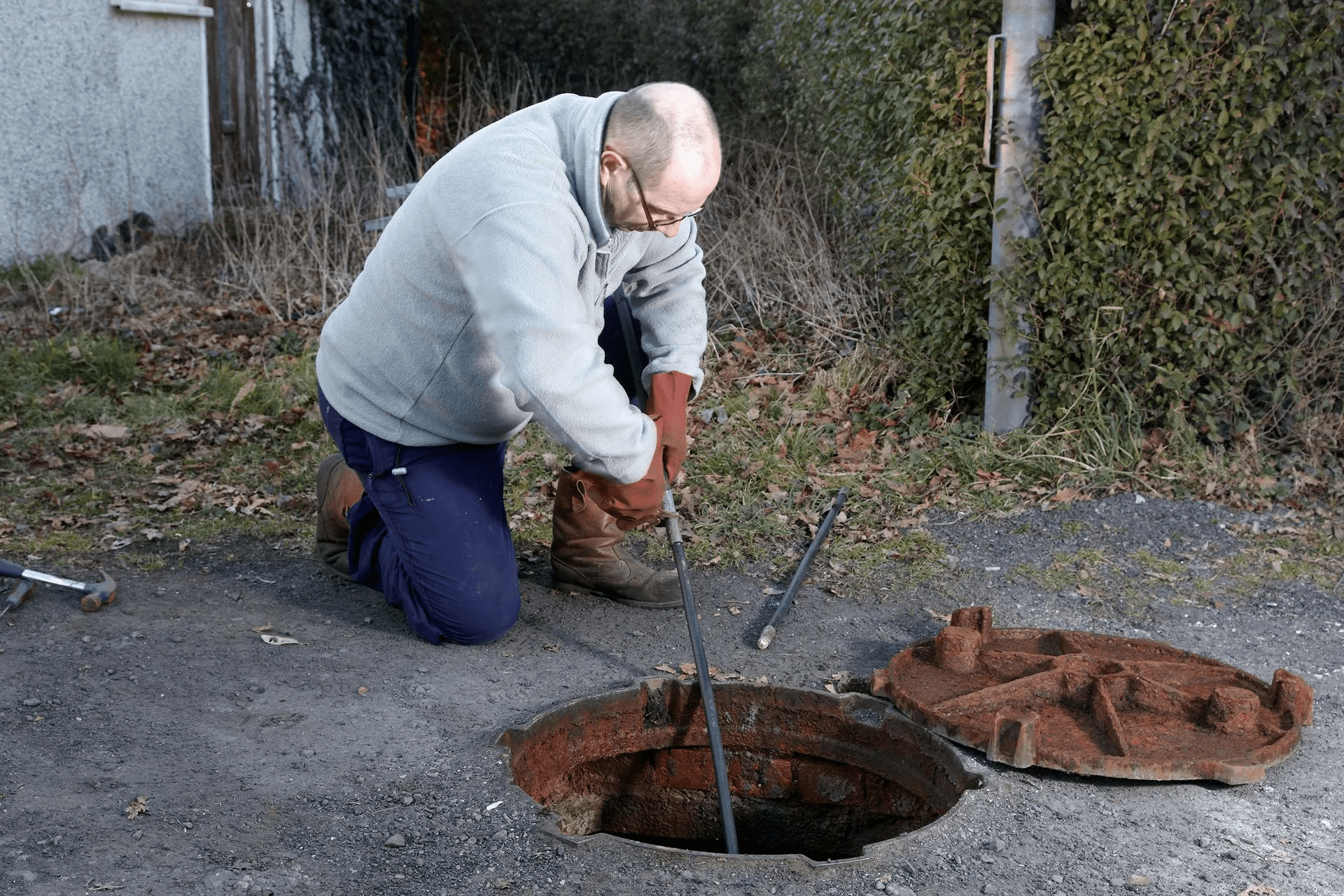 Man-Unclogging-Drain_Surefire-Septic