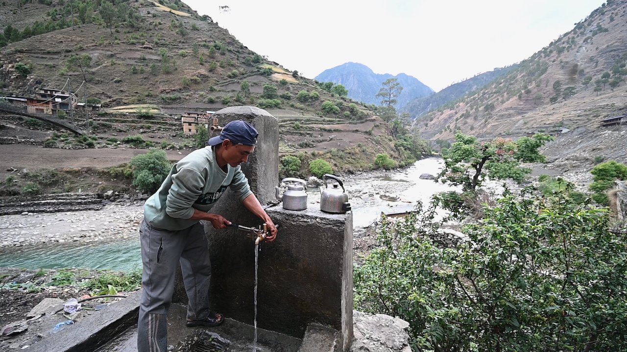 a man in a cap and with a wrench fixing a tap stand