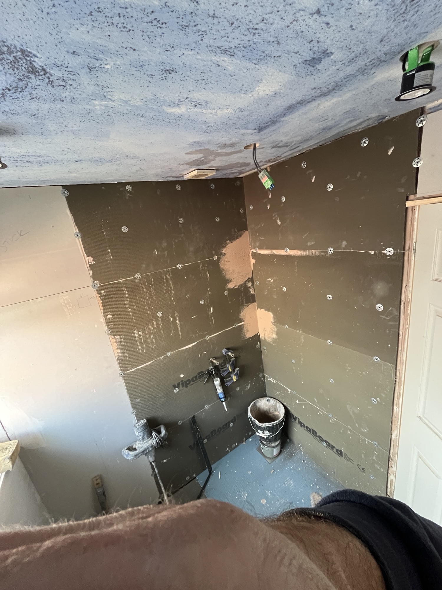 Waterproof backing boards installed on the walls of a room corner during a renovation