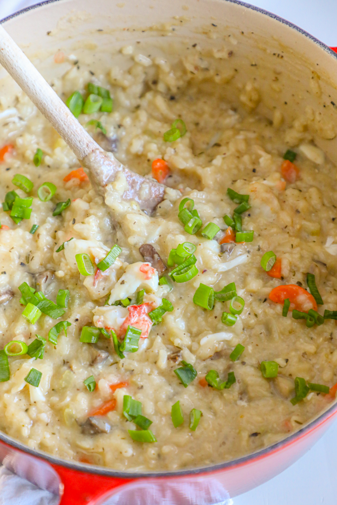 Easy shrimp risotto cooked in a pot with a wooden spoon.