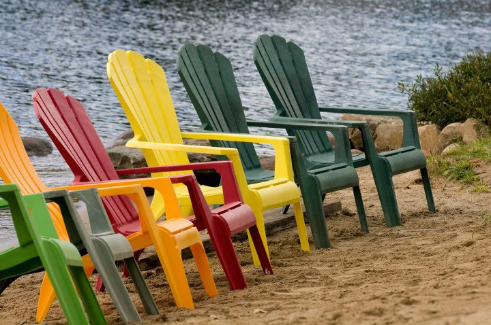 Colourful Muskoka chairs beside Baptiste Lake