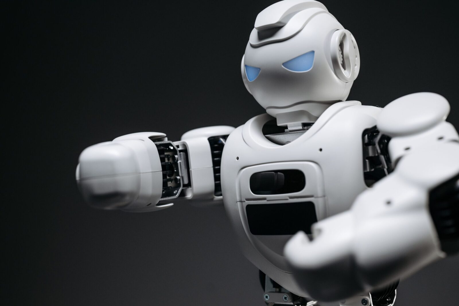 Detailed close-up of a high-tech white robot in a studio setting with a gray background.