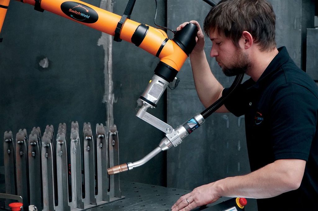 Man leading the SwitchWeld Welding Cobot to a weld