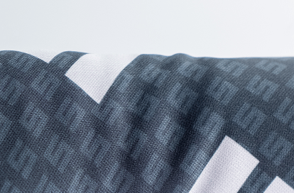 Close-up of dark blue patterned textile with geometric white shapes, draped across a surface.