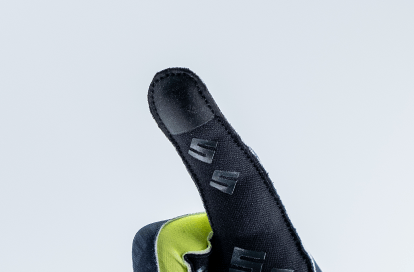 Close-up of a black fabric sneaker upper with lime-green interior and small S-shaped logos on the side.