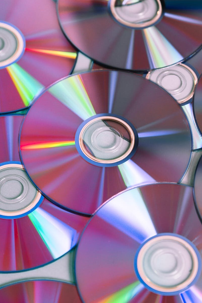 Vibrant close-up of compact discs showing colorful light refractions, ideal for themes of technology and entertainment.