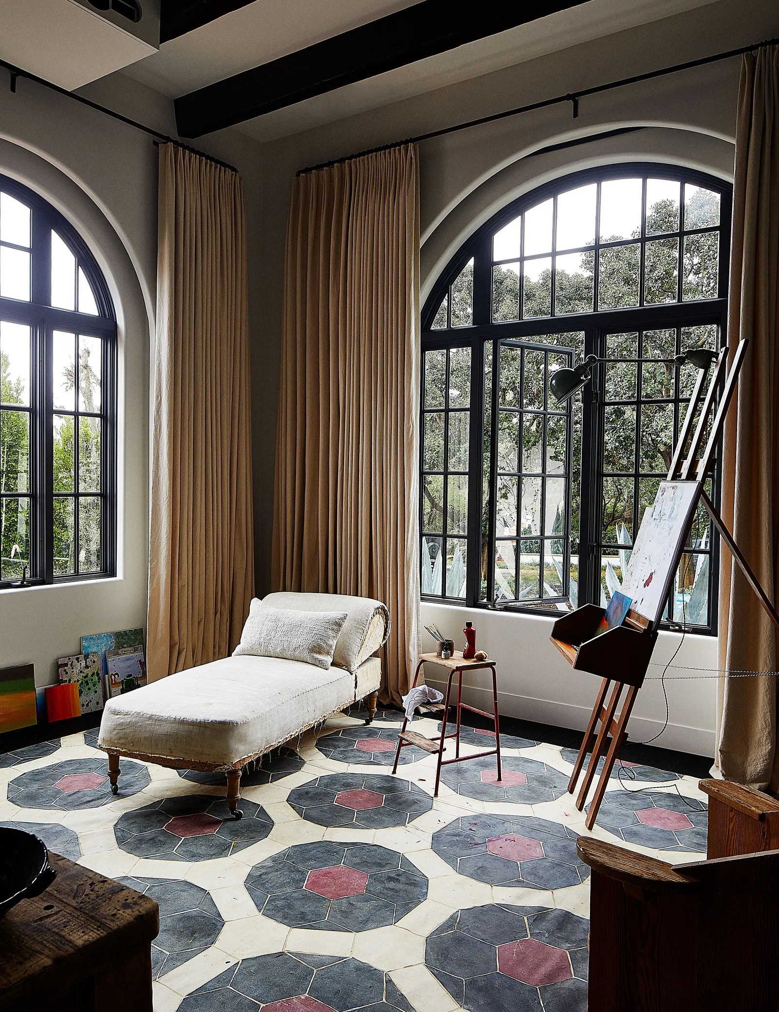 In the art studio, a 19th-century French chaise longue from Lee Stanton sits atop a painted floor cloth by Kaki Foley.