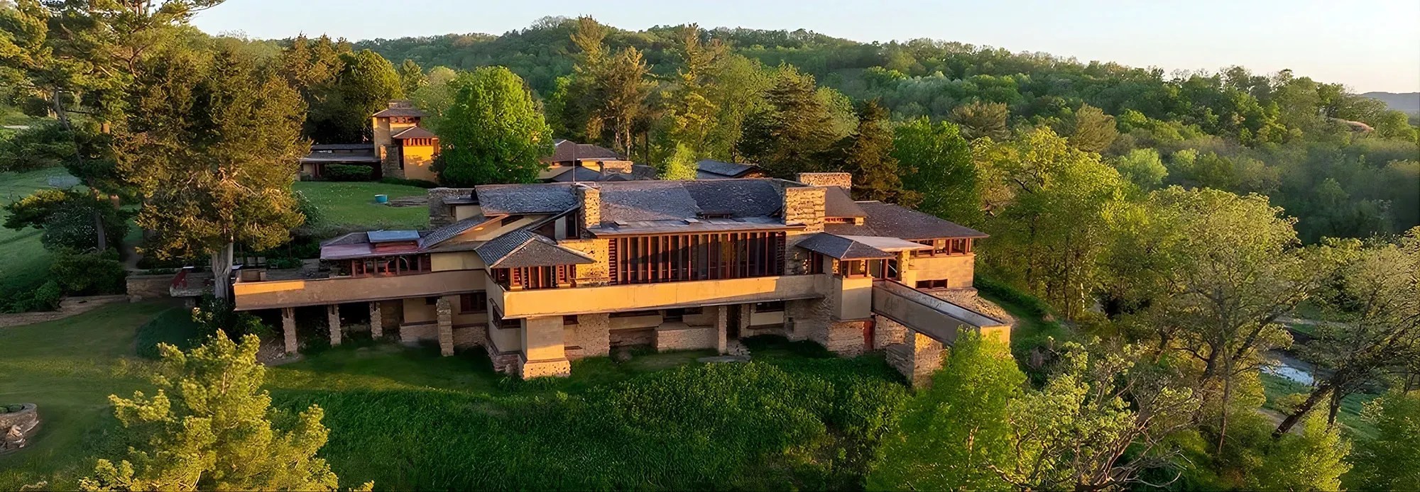 Aerial view of Frank Lloyd Wright's Taliesin estate nestled in the rolling green hills and lush landscape of Spring Green, Wisconsin.